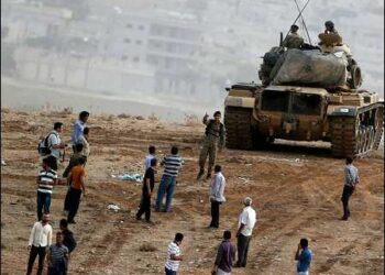 A Turkish officer warns Kurds watching over the Syrian town of Kobani to leave the top of a hill near Mursitpinar border October 11, 2014. Photo: Reuters