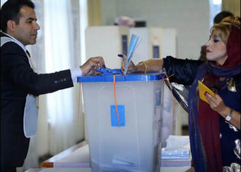 Kurdish woman casts her ballot at a polling station
