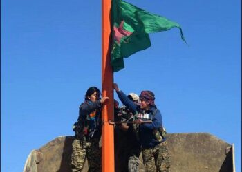 Syrian Kurdish female fighters raise the YPJ flag in Tel Saman town, north of Raqqa