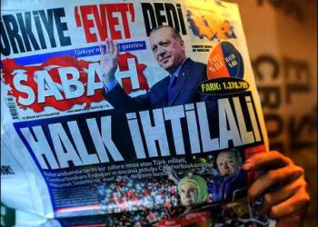A man reads Turkish newspaper with Erdogan photo