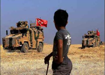 A Syrian boy watches as Turkish military vehicles take part in joint patrol in the Syrian village of Al Hashisha on the outskirts of the Kurdish Gire Spi (Tel Abyad) town in Syrian Kurdistan (Rojava) along the border with Turkey, on October 4, 2019. Photo: AP
