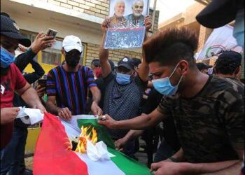 Supporters of Iraq's Shiite Popular Mobilization Forces (PMF) militias and supporters for the message of slain IRGC leader, Qassem Soleimani, burn a Kurdish flag during an attack on a Baghdad office of the Kurdistan Democratic Party KDP, October 17, 2020. Photo: AFP