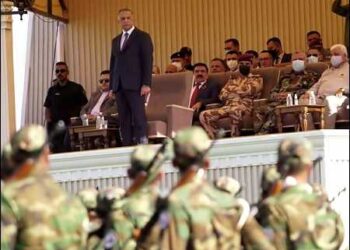 Iraqi Prime Minister Mustafa al-Kadhimi, (L), stands while the Shiite popular Mobilization Forces parade in Diyala, Iraq, June 26, 2021. Photo: AP