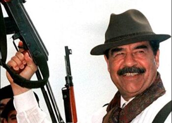 Saddam Hussein brandishing an AK 47 rifle during a visit to villages in northern Iraq in 1998. Photo: AFP