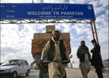 A Pashtun man passes a road sign while pulling supplies toward the Pakistan-Afghanistan border crossing in Chaman, November 28, 2011. Photo: Reuters