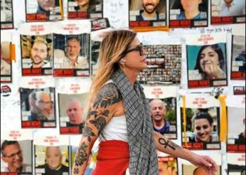A woman walks past pictures of Israeli hostages in Tel Aviv, Israel, February 12, 2024. Photo: AP