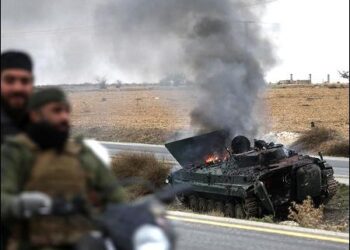 Turkey-backed Syrian Islamist opposition fighters drive past a burning Assad government armored vehicle south of Hama, Syria, December 7, 2024. Photo: AP