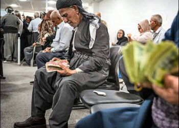 Some elderly Kurdish retirees count the cash from their long-delayed pensions, while others wait in line in Sulaimani city, Iraqi Kurdistan, July 2025. Photo: Channel8.com