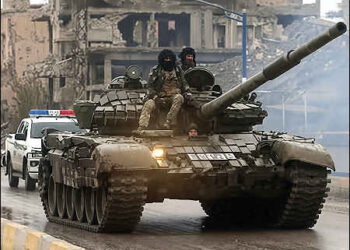 Syrian government militias sit on top of a tank, after the Kurdish Syrian Democratic Forces (SDF) withdrew from Deir al-Zor province and the Syrian govt militants took full control over the area, in Deir al-Zor, Syria, January 18, 2026. Photo: Reuters