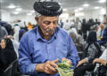 Some elderly Kurdish retirees count the cash from their long-delayed pensions, while others wait in line in Sulaimani city, Iraqi Kurdistan, July 2025. Photo: Channel8.com.