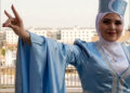 Turkmen woman wearing a hat with a Turkmen Front flag on the front, gestures the Turkish nationalist “Grey Wolf” sign at Erbil Citadel, Iraqi Kurdistan