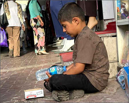 Poor child boy minor selling water chewing gum working people Sulaimani June 2026